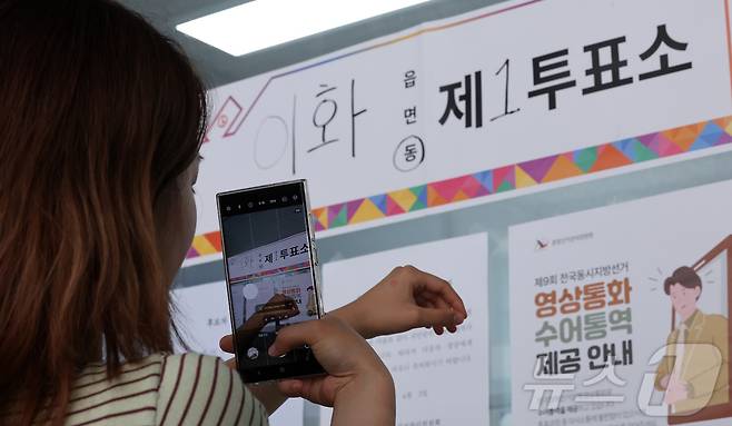 제9회 전국동시지방선거일인 3일 서울 종로구 상명대학교 예술디자인센터에 마련된 이화동 제1투표소에서 한 유권자가 인증샷을 남기고 있다. 2026.6.3 ⓒ 뉴스1 김성진 기자