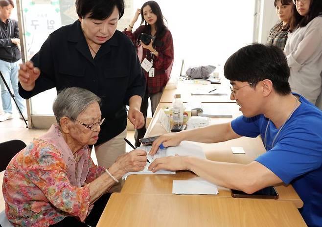 제9회 전국동시지방선거일인 3일 광주 동구 계림1동 2투표소에서 110세 김정자 어르신이 투표지를 받기 전 성명을 쓰고 있다. 뉴스1