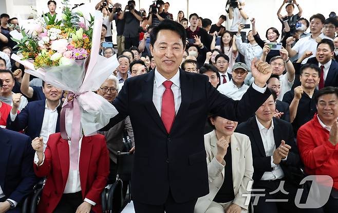 6·3 지방선거에서 당선된 오세훈 국민의힘 서울시장 후보가 4일 서울 종로구 선거사무소에서 꽃다발을 전달 받고 환호 하고 있다. 2026.6.4 ⓒ 뉴스1 김도우 기자