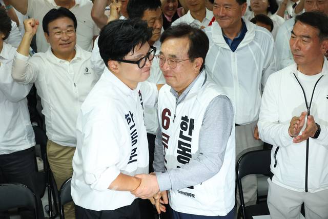 한동훈 무소속 부산 북갑 국회의원 보궐선거 후보가 4일 부산 북구 선거사무소에서 선거방송을 시청하기 위해 입장해 서병수 명예선대위원장과 포옹하고 있다. [연합뉴스]