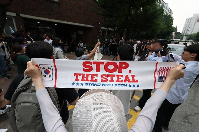 전날 9회 전국동시지방선거 및 국회의원 재·보궐선거 투표용지 부족으로 투표 시간이 오후 10시까지 연장됐던 서울 송파구 잠실7동 제2투표소 앞에서 4일 투표함 반출에 반대하는 시민들이 손팻말을 들고 구호를 외치고 있다. 연합뉴스
