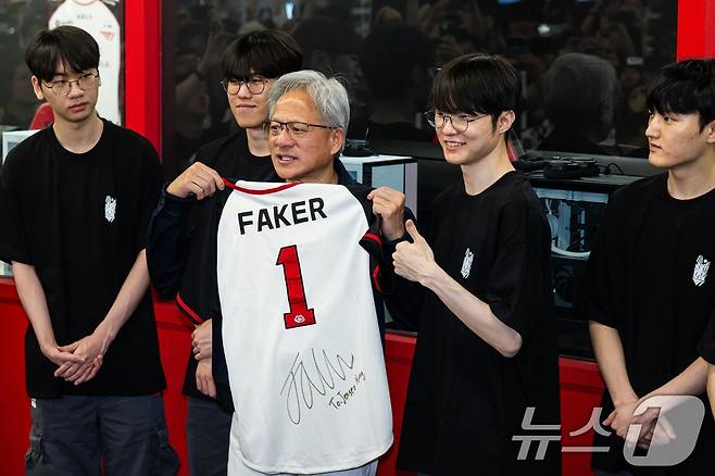 젠슨 황 엔비디아 최고경영자(CEO)가 5일 서울 마포구 ‘T1 베이스 캠프’를 방문해 ‘페이커‘ 이상혁을 비롯한 e스포츠 구단 T1의 리그 오브 레전드(LoL) 선수단에게 선물 받은 ‘페이커’ 사인 유니폼을 들어보이고 있다. (공동취재) 2026.6.5 ⓒ 뉴스1 이광호 기자