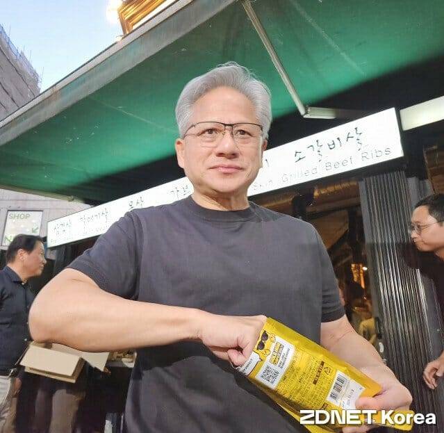 젠슨 황 엔비디아 CEO가 5일 서울 홍대서 SK하이닉스의 'HBM 칩스' 과자를 먹으며 기자들의 질문에 답하고 있다 (사진=지디넷코리아)