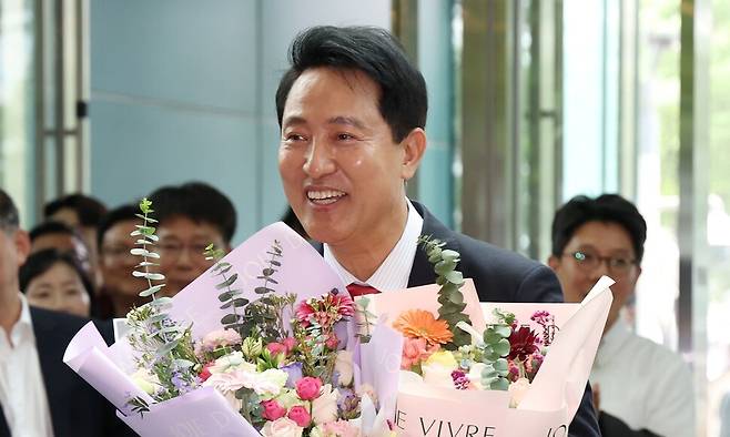 오세훈 서울시장이 4일 서울시청 로비에서 꽃다발을 받은 뒤 기뻐하고 있다. 연합뉴스