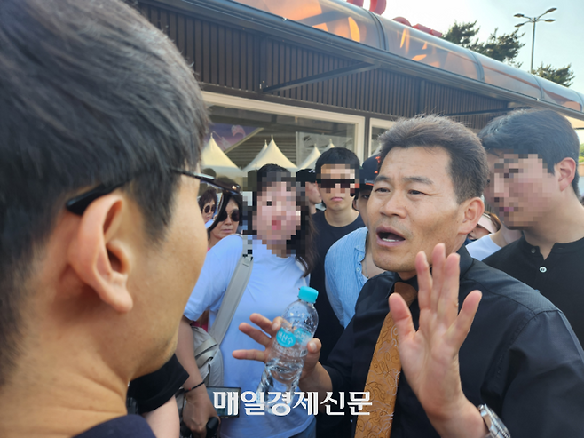 전한길 전 한국사 강사가 5일 저녁 올림픽공원 핸드볼경기장을 빠져나오는 남성에게 말하고 있다.  [조병연 기자]