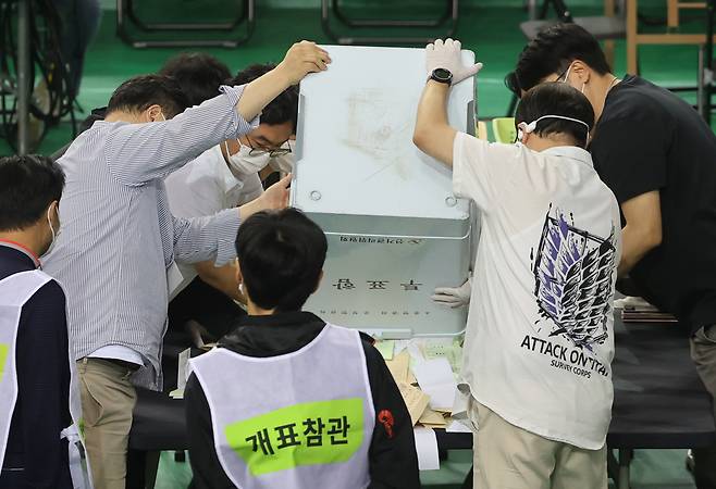 5일 서울 송파구 잠실7동 제2투표소에서 이송된 투표함이 개표소인 올림픽공원 핸드볼경기장에 도착해 참관인이 지켜보는 가운데 투표함을 열고 있다.  [연합]