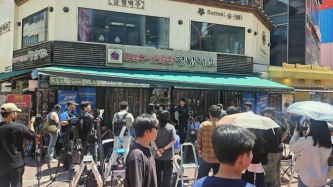 [서울=뉴시스] 젠슨 황 엔비디아 최고경영자(CEO)가 5일 오후 김포공항을 통해 입국했다. 황 CEO는 이날 저녁 서울 마포구 홍대입구역 인근 식당에서 최태원 SK그룹 회장, 구광모 LG그룹 회장 등과 저녁 식사를 함께할 예정이다. 사진은 황 CEO와 최 회장 등의 저녁 식사가 예정된 식당 앞이 시민과 취재진 등으로 붐비는 모습. 2026.06.05 photo@newsis.com *재판매 및 DB 금지