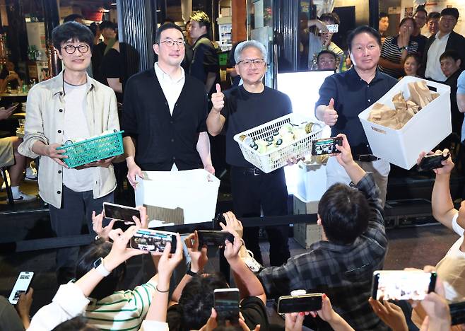 젠슨 황 엔비디아 최고경영자(CEO)가 5일 서울 마포구 홍대 인근 삼겹살 음식점 '형님 저요'에서 최태원 SK그룹 회장, 구광모 LG그룹 회장, 이해진 네이버 의장과 '삼소(삼겹살·소주) 회동''을 하며 각종 간식을 시민들에게 나눠주고 있다. 연합뉴스