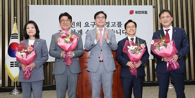 국민의힘 송언석 원내대표와 6·3 재보궐선거에서 당선된 의원들이 5일 국회에서 열린 의원총회에서 두 손을 맞잡고 기념 촬영을 하고 있다. 왼쪽부터 대구 달성 이진숙 의원, 경기 평택을 유의동 의원, 송 원내대표, 충남 공주ㆍ부여ㆍ청양 윤용근 의원, 울산 남갑 김태규 의원. 연합뉴스