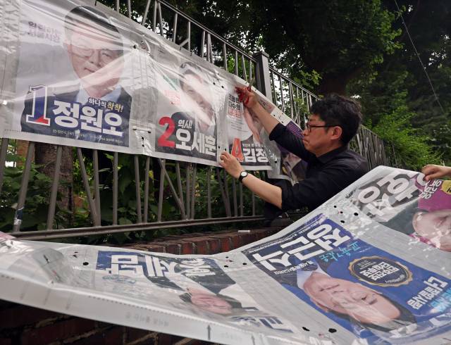 4일 서울 종로구 예술가의 집 담장에서 관계자들이 선거 벽보를 철거하고 있다. 연합뉴스