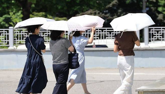 서울 서초구에서 시민들이 내리쬐는 땡볕에 양산을 쓰고 걸어가고 있다. (사진=연합뉴스)
