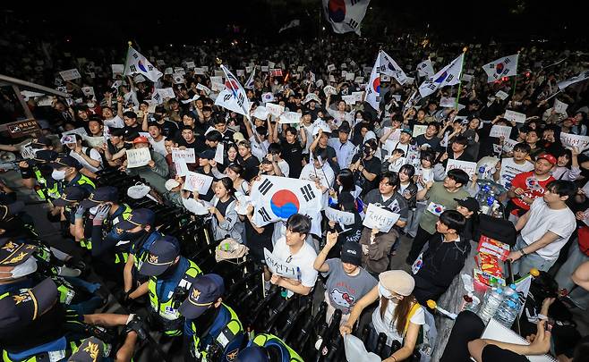 6일 새벽 서울 송파구 올림픽공원 핸드볼경기장 앞에서 시민들이 태극기와 ‘재선거’라고 적힌 손팻말을 들고 선거 관리 부실에 항의하고 있다. 이들은 투표용지 부족 사태와 개표 과정에 대한 문제 제기를 하며 경기장 주변에 모였다. / 고운호 기자