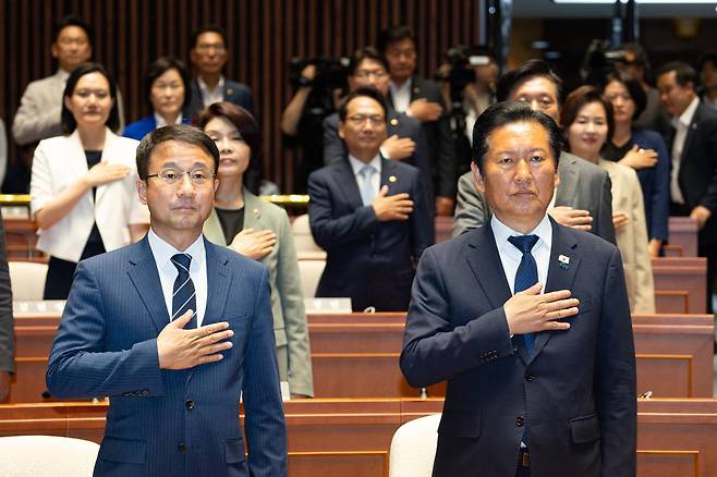 정청래(오른쪽) 더불어민주당 대표와 한병도 원내대표를 비롯한 의원들이 5일 서울 여의도 국회에서 열린 의원총회에서 국민의례를 하고 있다. 뉴스1