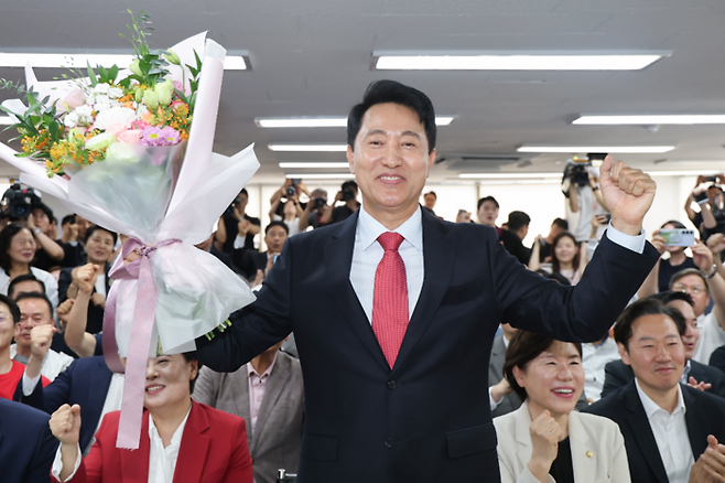 국민의힘 오세훈 서울시장 후보가 제9회 전국동시지방선거일 다음날인 4일 서울 종로구 대왕빌딩에 마련된 선거사무소에서 당선이 유력해지자 꽃다발을 들고 기뻐하고 있다. [연합뉴스]