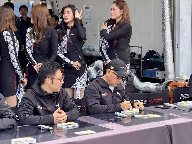 [시즈오카(일본)=뉴시스] 김민성 기자 = 6일 오전 일본 시즈오카현 후지스피드웨이에서 열린 '슈퍼 타이큐 시리즈' 3라운드에 앞서 토요다 아키오 토요타자동차 회장(오른쪽)이 자신아들인 토요다 다이스케 우븐 바이 토요타사장과 함께 팬들에게 사인하고 있다. 2026.06.06. kms@newsis.com. *재판매 및 DB 금지