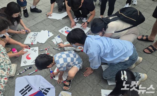 6일 오후 서울 송파고 올림픽공원 일대에서 투표 용지 부족 사태로 촉발된 '재선거 시위'에 참여한 사람들이 피켓을 만들고 있다. 주보배 기자