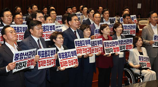 송언석 국민의힘 원내대표를 비롯한 참석 의원들이 4일 국회에서 열린 긴급 의원총회에서 투표용지 부족 사태와 관련한 중앙선관위 규탄 손팻말을 들고 있다. /연합뉴스