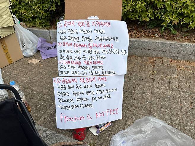 8일 오전 서울 송파구 올림픽공원 투표소 봉쇄 시위 현장에 붙어 있던 ‘재선거 구호와 태극기로 통일하자’는 내용의 팻말(종이 윗부분)이 뜯겨 있다. 김예정 기자