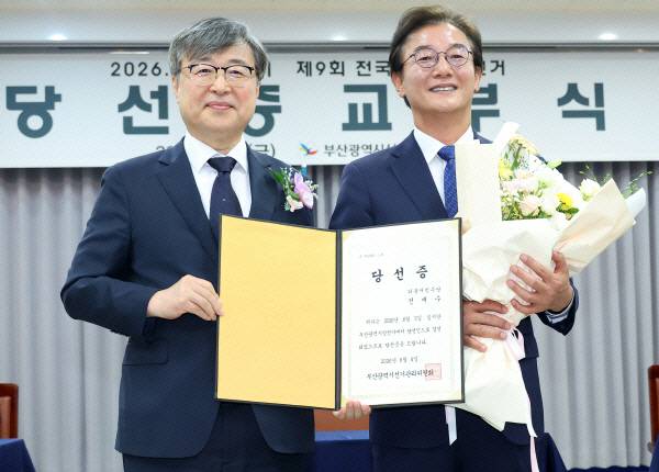 더불어민주당 전재수 부산시장 당선인이 지난 5일 부산 연제구 부산시선관위에서 열린 당선증 교부식에서 김문관 부산시선거관리위원장으로부터 당선증을 받은 뒤 기념 촬영하고있다. 연합뉴스