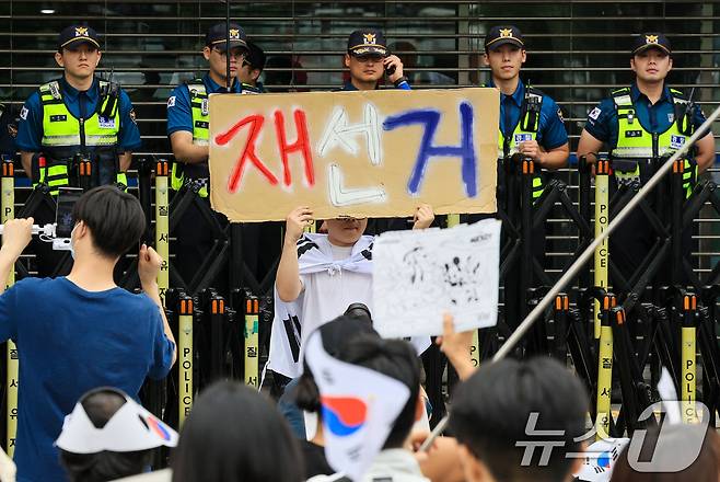 제9회 전국동시지방선거 투표용지 부족 사태에 반발한 시민들이 7일 서울 송파구 올림픽공원 핸드볼경기장 개표소 앞에 모여 재선거를 요구하는 구호를 외치고 있다. 2026.6.7 ⓒ 뉴스1 이호윤 기자
