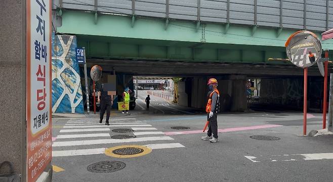 9일 서울 노원구 아파트 공사 현장 인근에서 건설사 소속 안전 요원이 시민 통행을 안내하고 있다. /현정민 기자