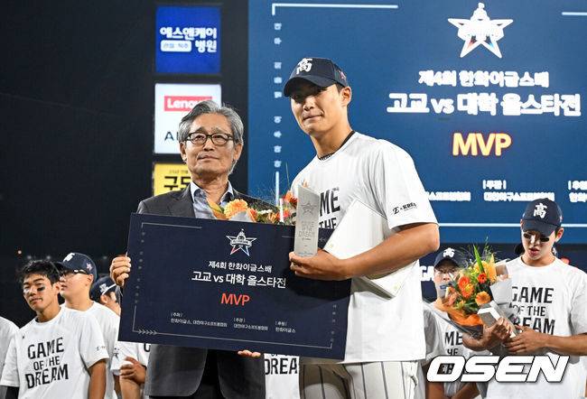 [OSEN=대전, 조은정 기자]제4회 한화이글스배 고교vs대학 홈런더비 결승전이 8일 대전한화생명볼파크에서 열렸다.고교 올스타는 18세 이하 청소년 대표팀을 맡고 있는 덕수고 정윤진 감독이 지휘한다. 대학 올스타는 23세 이하 대표팀 사령탑인 성균관대 이연수 감독이 이끈다. 양 팀 선수단은 프로 10개 구단 스카우트 팀장들의 협의를 통해 선발됐다.MVP를 차지한 디자인고 박근서가 KBSA 양해영 회장과 포즈를 취하고 있다. 2026.06.08 /cej@osen.co.kr