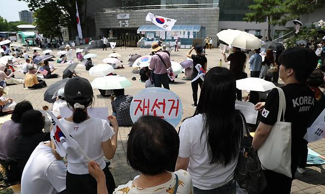 6·3 지방선거 투표용지 부족 사태를 규탄하며 재선거를 요구하는 '잠실 개표소 봉쇄 시위'가 계속되고 있는 9일 서울 송파구 올림픽공원 핸드볼경기장에서 시민들이 구호를 외치고 있다. 연합뉴스