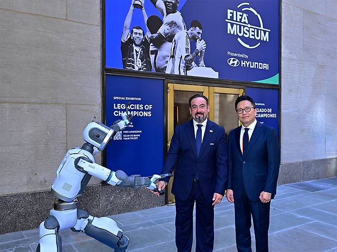 FIFA 뮤지엄 입구에서 아틀라스와 기념 사진을 촬영하는 FIFA 뮤지엄 마르코 파초네 관장(왼쪽)과 현대차 브랜드마케팅본부장 지성원 부사장. /사진=현대차 제공