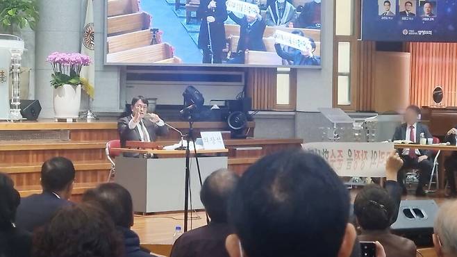 2025년 12월 열린 당회에서 최정규 목사가 당회가 무효라고 주장하는 교인들을 제지하고 있다. 뉴스앤조이 자료사진