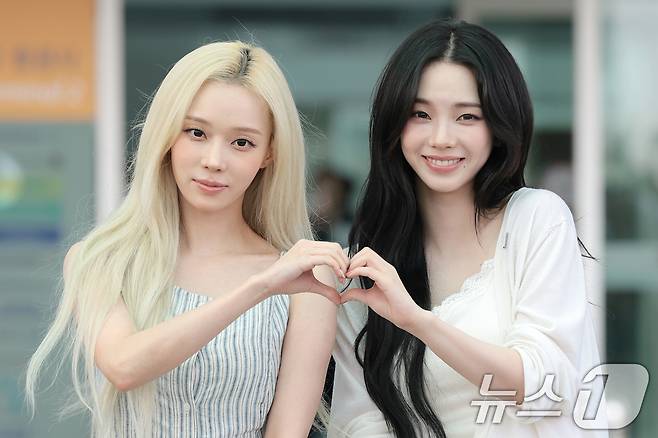 에스파 윈터와 카리나(오른쪽)가 월드컵 응원을 위해 10일 인천국제공항에 도착해 멕시코로 출국하기 전 하트 포즈를 취하고 있다. ⓒ 뉴스1 권현진 기자