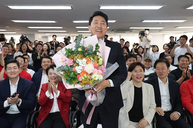 6·3 지방선거에서 서울시장 당선이 사실상 확정된 오세훈 국민의힘 후보가 제9회 전국동시지방선거일 다음날인 4일 서울 종로구 대왕빌딩에 마련된 선거사무소에서 입장을 밝힌 뒤 꽃다발을 들고 있다. [연합]