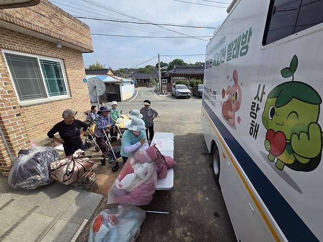1일 전남 영암군 군서면 동호마을회관 앞에서 지역 주민들이 이동식 빨래방 앞에 이불을 내놓는 모습.