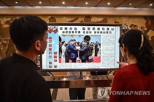 북중 정상회담 보도를 보는 북한 주민들 [AFP=연합뉴스 자료사진. 재판매 및 DB 금지]
