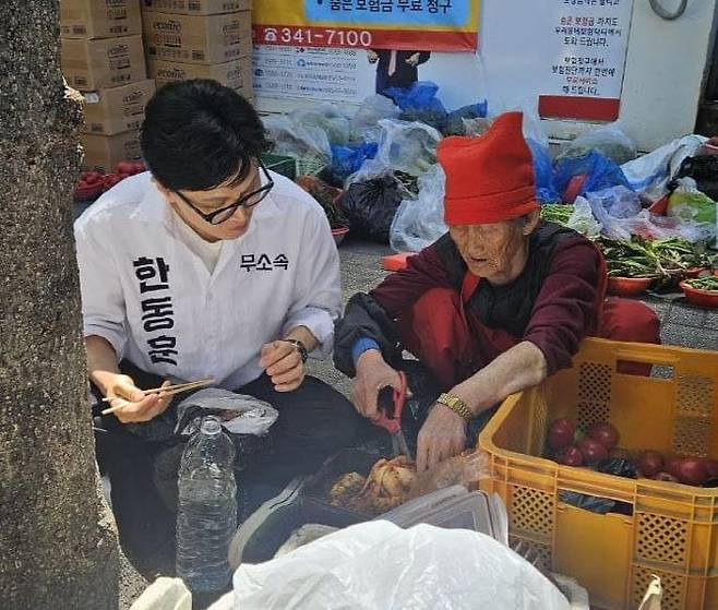 지난달 8일 부산 북구 구포시장 인근 길거리에서 김복악(80) 할머니가 한동훈 의원에게 찰밥과 김치를 건네고 있다. /한동훈 의원 SNS