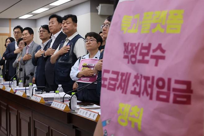 11일 정부세종청사에서 열린 최저임금위원회 전원회의 참석자들이 국기에 대한 경례를 하는 모습./연합뉴스