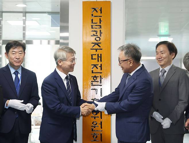 지난 8일 전남 나주시 빛가람복합문화체육센터에서 열린 전남광주대전환기획위원회 출범식에서 민형배 전남광주통합특별시장 당선인과 정은승 위원장이 현판식을 갖고 악수하고 있다. 연합뉴스