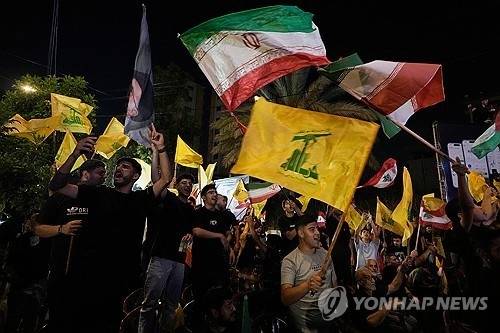 헤즈볼라 지지자들이 레바논 수도 베이루트 남쪽 외곽의 다히예에서 미국-이스라엘 군사 작전에 반대하는 집회에서 헤즈볼라 깃발과 이란 국기를 흔들고 있다. [AP 연합뉴스]
