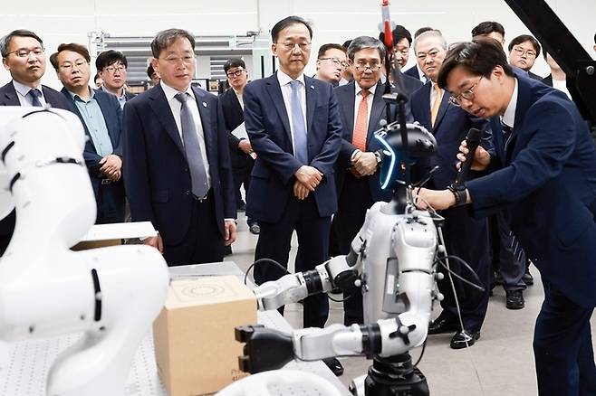 김윤덕 건설교통부 장관(가운데)  등이 11일 전북대에서 열린 ‘인공지능(AI) 건설·로봇 혁신센터’ 설립을 위한 업무협약을 체결한 뒤 피지컬AI 실증센터를 찾아 인공지능 로봇에 대한 설명을 듣고 있다. [전북도]