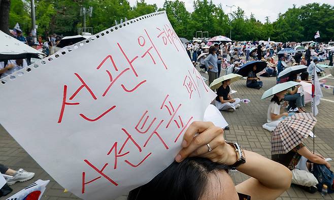 제9회 전국동시지방선거 투표용지 부족 사태에 항의하는 개표소 봉쇄 시위가 이어지고 있는 11일 서울 송파구 올림픽공원 핸드볼경기장 앞에서 시위대가 재선거를 요구하는 구호를 외치고 있다. 유희태 기자