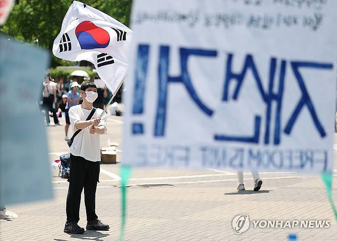 이어지는 개표소 봉쇄 시위…태극기 흔드는 참가자 (서울=연합뉴스) 김성민 기자 = 6·3 지방선거 투표용지 부족 사태를 규탄하며 재선거를 요구하는 '잠실 개표소 봉쇄 시위'가 계속되고 있는 9일 서울 송파구 올림픽공원 핸드볼경기장에서 한 참가자가 태극기를 흔들고 있다. 2026.6.9 ksm7976@yna.co.kr