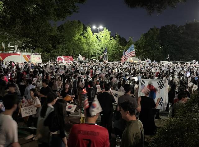 6·3 지방선거 투표용지 부족 사태로 촉발된 잠실 개표소 봉쇄 시위가 주말을 앞두고 12일 저녁 다시 규모를 커져 인파로 북적이고 있다. 연합뉴스