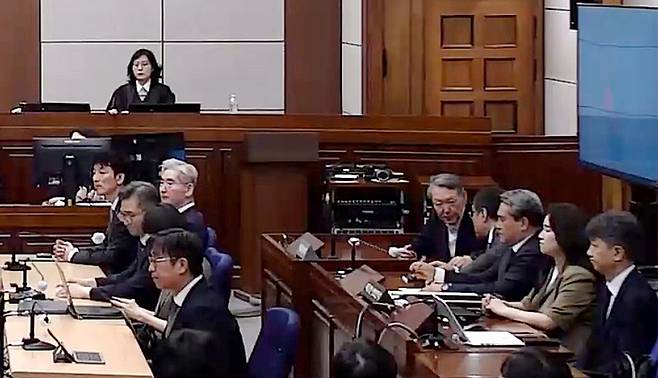 윤석열 전 대통령이 12일 서울 서초구 서울중앙지방법원에서 열린 일반이적 및 직권남용권리행사방해 혐의 1심 선고 공판에 출석해 변호인단 배보윤 변호사와 대화하고 있다. 서울중앙지법 형사합의36부(이정엽 부장판사)는 이날 윤 전 대통령에게 징역 30년을 선고했다. [서울중앙지법]