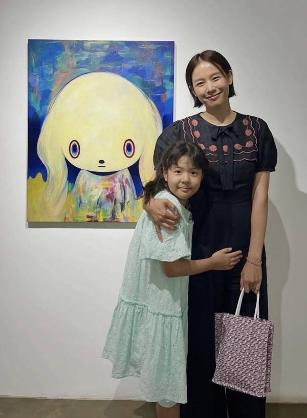Actress Jo Yoon-hee shared recent photos on her social media of herself visiting an exhibition with her daughter, Roar, for the first time in about four months. In the photos, Jo Yoon-hee has transformed from her previous long hair to a short hairstyle that falls just above her jawline, while Roar, seen hugging her mothers waist, exudes an aura of significant growth.Jo Yoon-hee spent time with her daughter while viewing Maiko Kobayashis exhibition. Wearing a green dress, Roar stayed by her mothers side, displaying a heartwarming mother-daughter bond.Compared to photos taken at Langkawi Beach in Malaysia last February, Roar has grown noticeably taller, and Jo Yoon-hee also projected a lighter impression with her new hairstyle. Jo Yoon-hee is currently raising her daughter Roar alone and shares updates on her life abroad and school life through social media.
