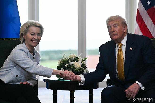 (AFP=뉴스1) = 도널드 트럼프 미국 대통령이 27일(현지시간) 영국 스코틀랜드 턴베리에서 우르줄라 폰 데어 라이엔 유럽연합(EU) 집행위원회 위원장과 EU에 대한 상호관세 및 자동차 관세를 15%로 낮추기로 한 무역 협상에 합의한 후 악수하고 있다. 2025.7.27  ⓒ AFP=뉴스1  Copyright (C) 뉴스1. All rights reserved. 무단 전재 및 재배포,  AI학습 이용 금지. /사진=(AFP=뉴스1)
