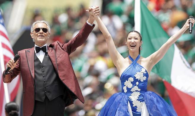 가수 이재와 이탈리아 성악가 안드레아 보첼리(왼쪽사진)가 2026 국제축구연맹(FIFA) 북중미 월드컵 개막식에서 주제가 ‘DNA’를 부르고 있다.&nbsp;TASS연합