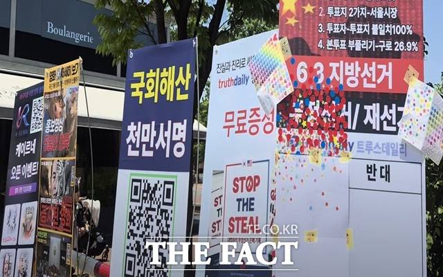서울지하철 5호선과 9호선이 다니는 올림픽공원역 출구 앞에는 태극기와 성조기를 판매하는 상인들이 여전히 자리를 지키고 있었고, 한쪽에는 "부정선거 의혹에 동의하냐"고 묻는 스티커 투표판과 관련 영화를 상영하는 플랫폼 홍보 플래카드가 크게 걸려 있었다. /서울 올림픽공원=오승혁 기자