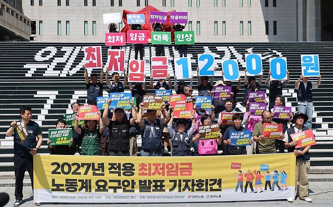 15일 서울 종로구 세종문화회관 계단에서 열린 2027년 적용 최저임금 노동계 요구안 발표 민주노총-한국노총 기자회견에서 참석자들이 구호를 외치고 있다. 뉴시스