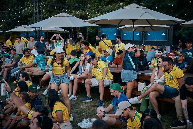 14일 미국 뉴욕 브루클린 브리지 공원에 모인 브라질 축구팬들이 2026 북중미 월드컵 C조 브라질과 모로코의 경기를 대형 스크린으로 지켜보고 있다. AP