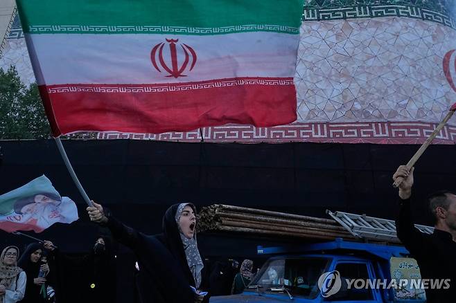 미국과 협상 반대하는 이란 여성 시위자 (테헤란 AP=연합뉴스) 2026년 6월 14일 이란 수도 테헤란의 이슬람혁명 광장에서 한 여성이 이란 국기를 들고 미국과의 협상을 반대하는 구호를 외치고 있다. (AP Photo/Vahid Salemi) 2026.6.15. [이스라엘 사용 금지. 이스라엘 매체, 이란 외 페르시아어 TV 방송국 접근허용 금지, BBC 페르시아어, VOA 페르시아어, 마노토TV, 이란 인터내셔널 TV 접근허용 절대 금지]
