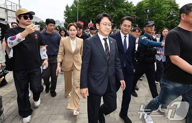 임오경, 천준호, 전용기 더불어민주당 의원이 17일 서울 송파구 올림픽공원 핸드볼경기장 앞에서 투표용지 부족 사태를 규탄하는 시민들에게 항의를 받고 있다. 2026.6.17 ⓒ 뉴스1 김도우 기자
